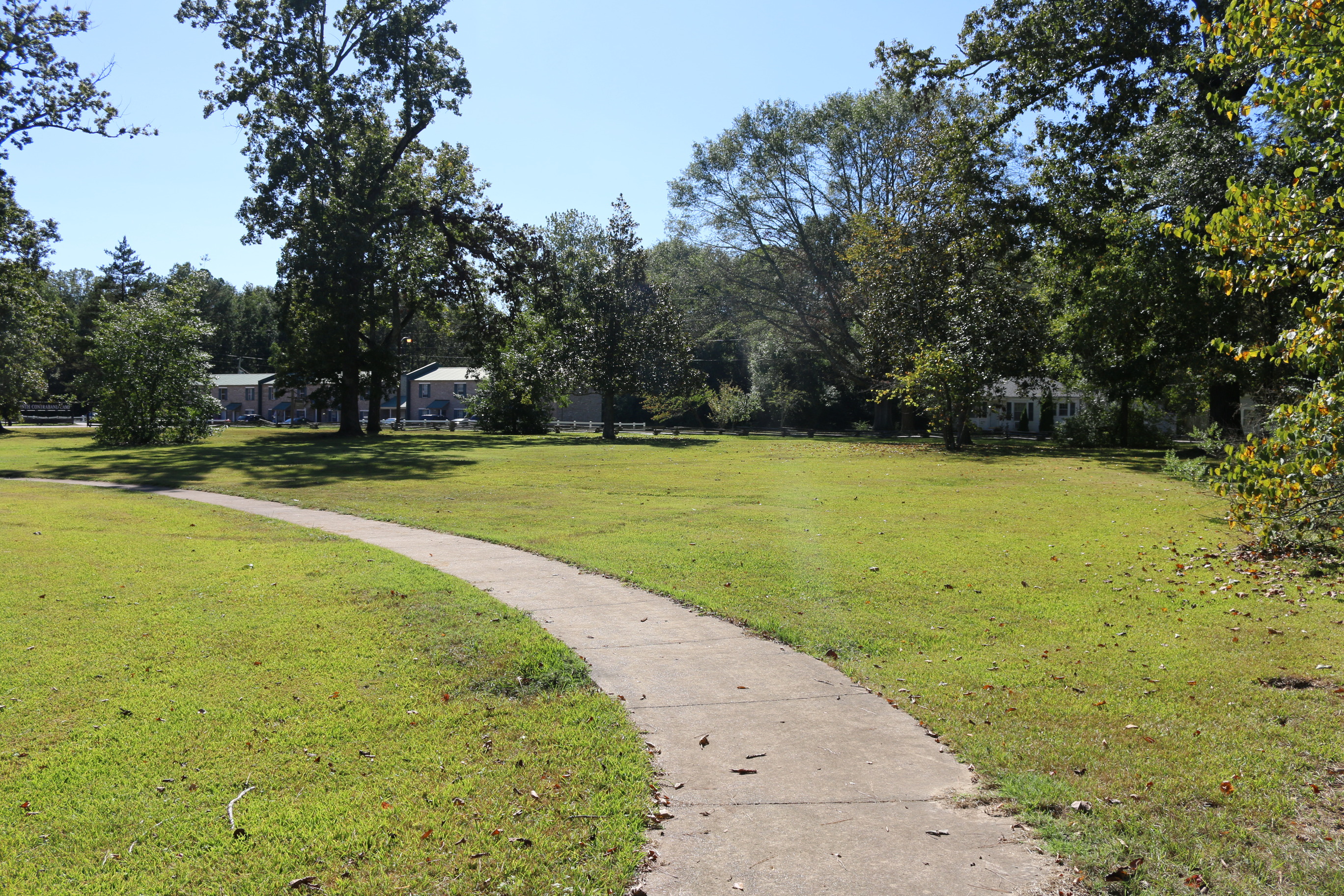 The sidewalk at the Corinth Contraband Camp site stretches into the distance, with North Parkway Street in the background.