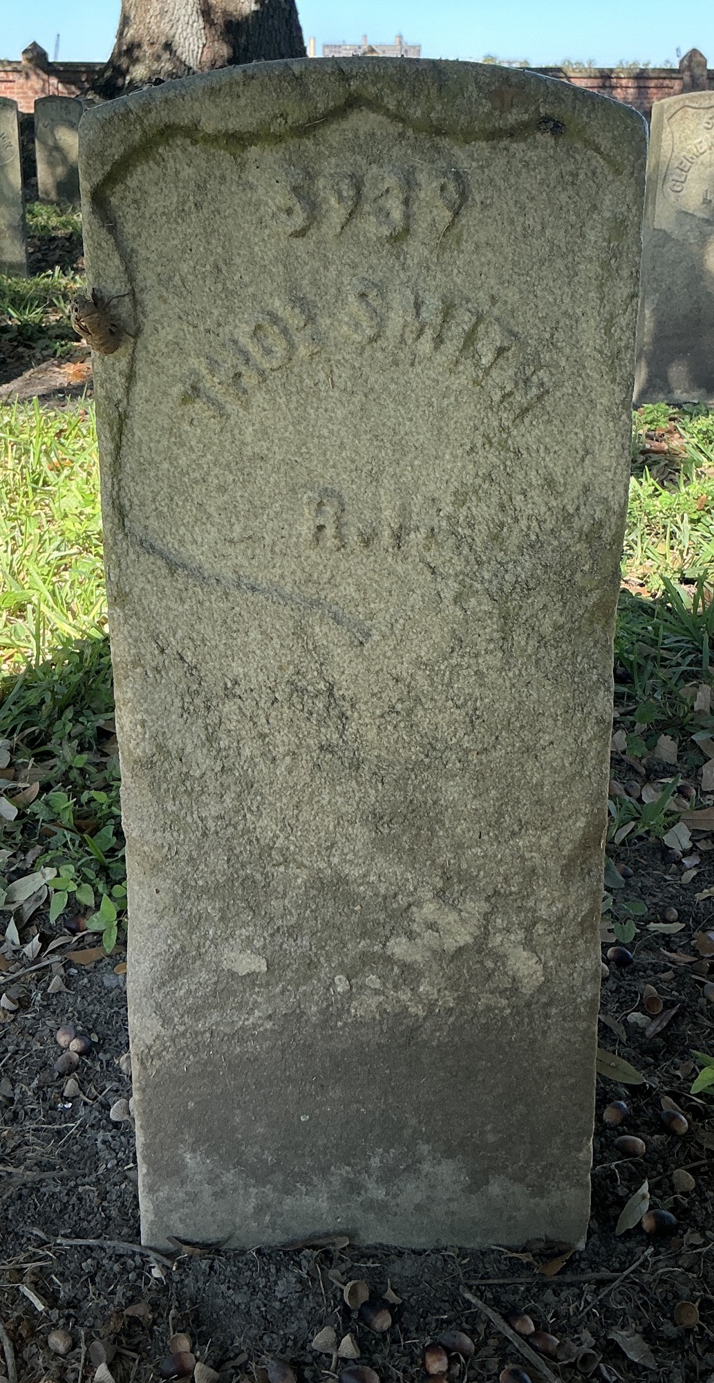 Front of historic upright marble headstone with recessed shield face.