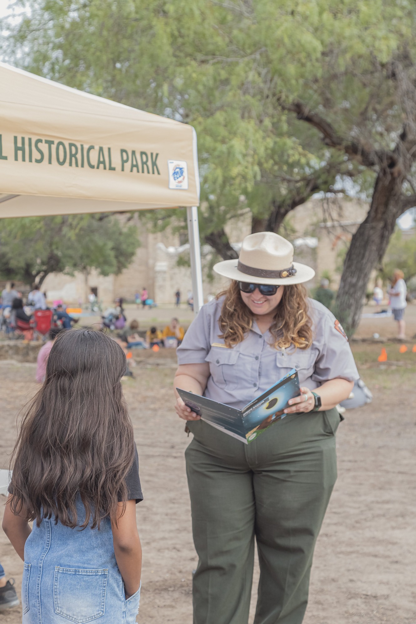 Park Ranger checks a girl's Junior Ranger Program.