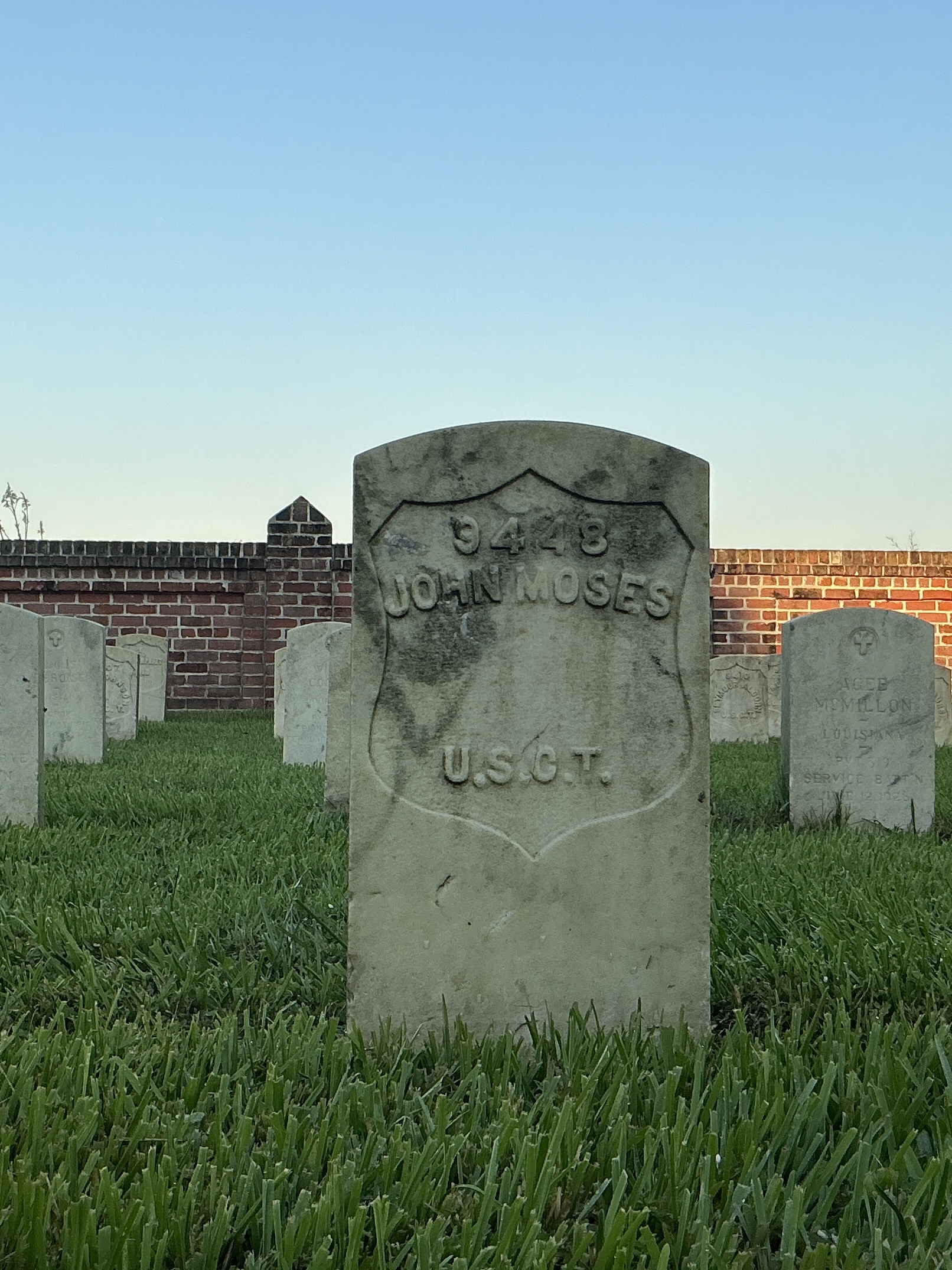 Front of historic upright marble headstone with recessed shield face.