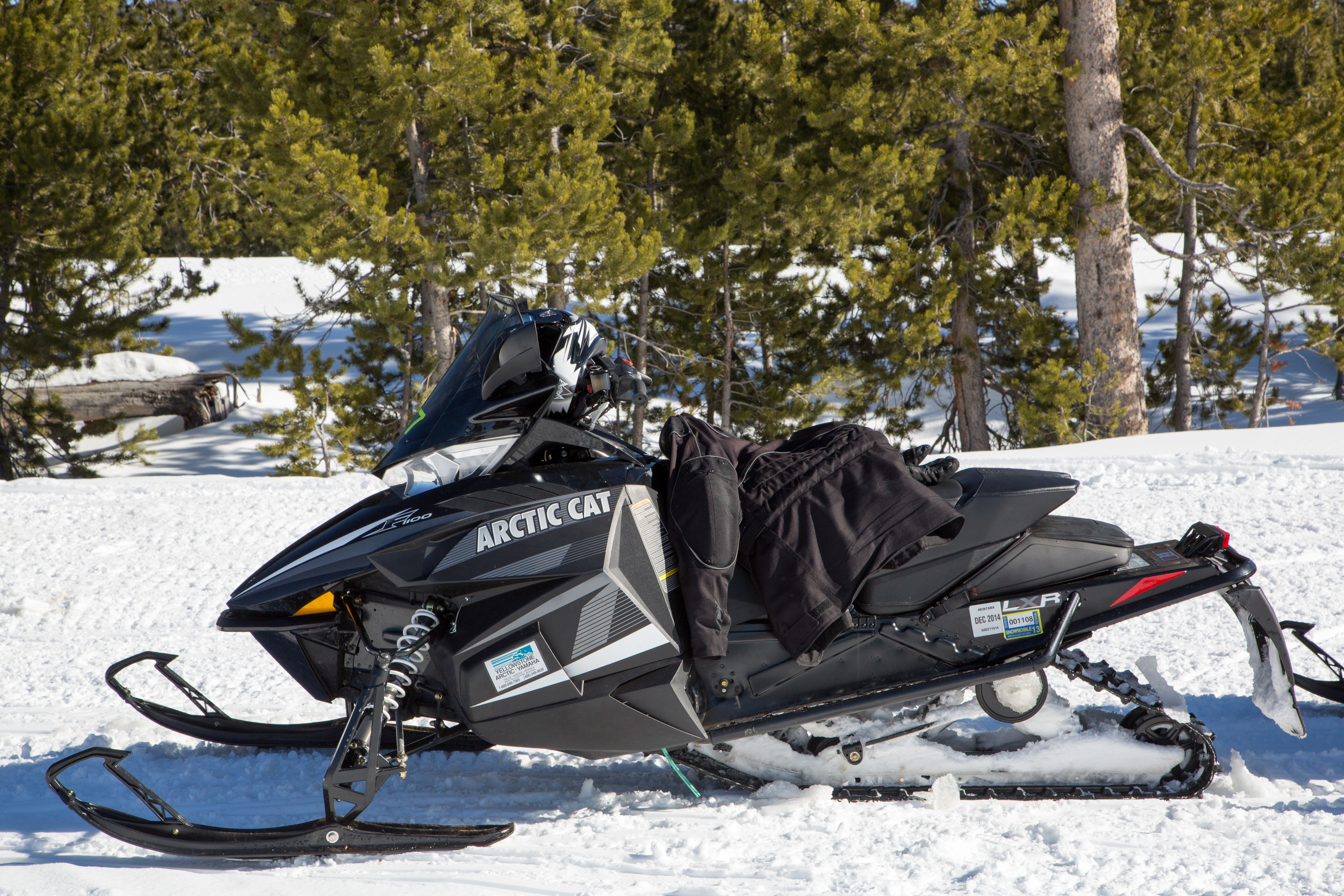 A black Arctic Cat brand snowmobile is parked by itself