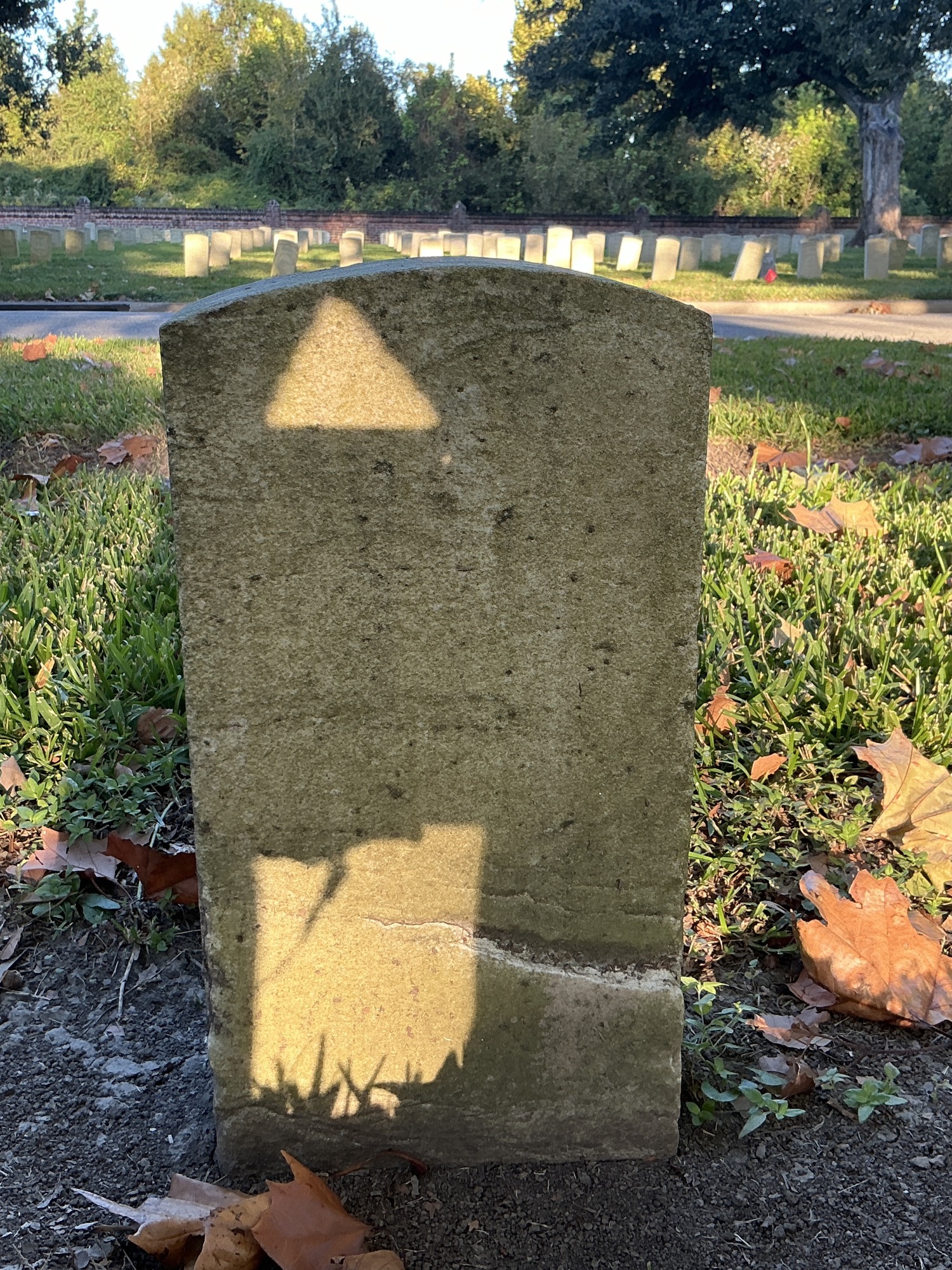 Back of historic upright marble headstone with recessed shield face.