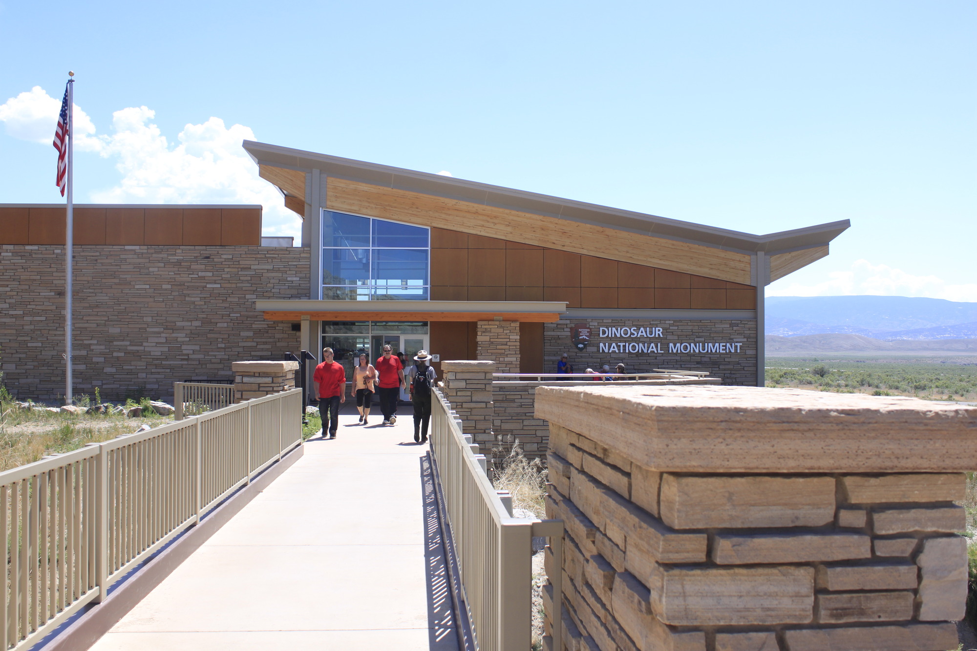 A view looking down the entrance bridge to the Quarry Visitor Center with people visible at the far end.