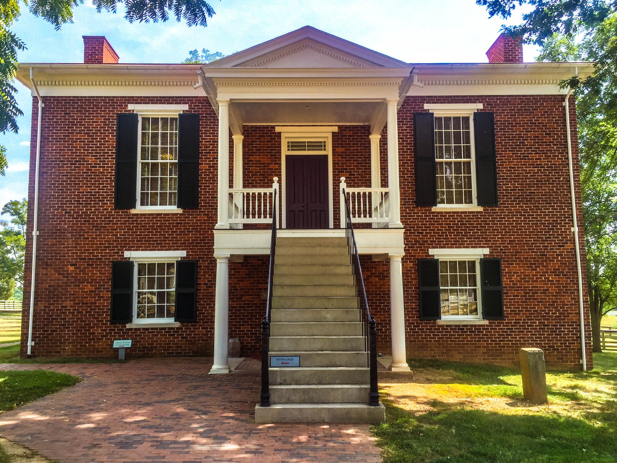 Appomattox Court House is a two story brick building with four windows and an outdoor stairway going to the second floor.