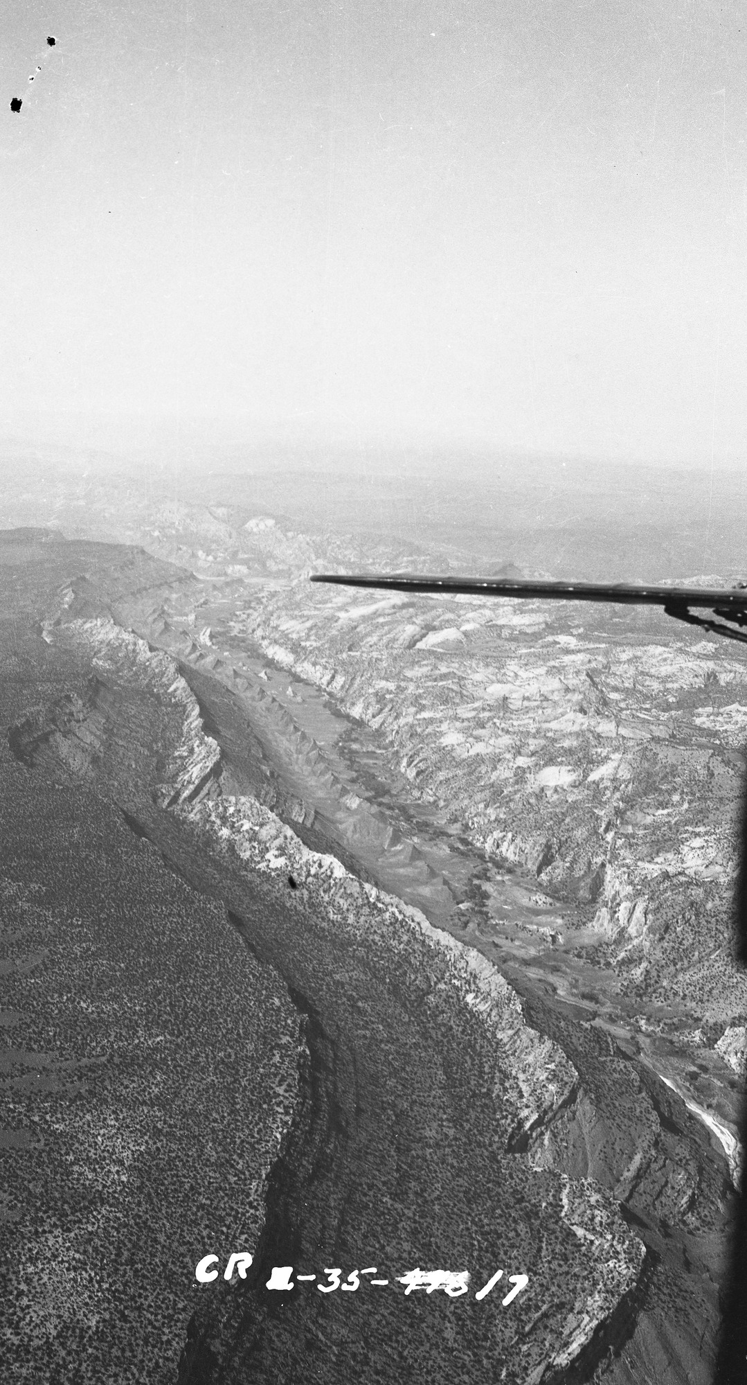 Plane wing and long valley with ridge running down the middle. 