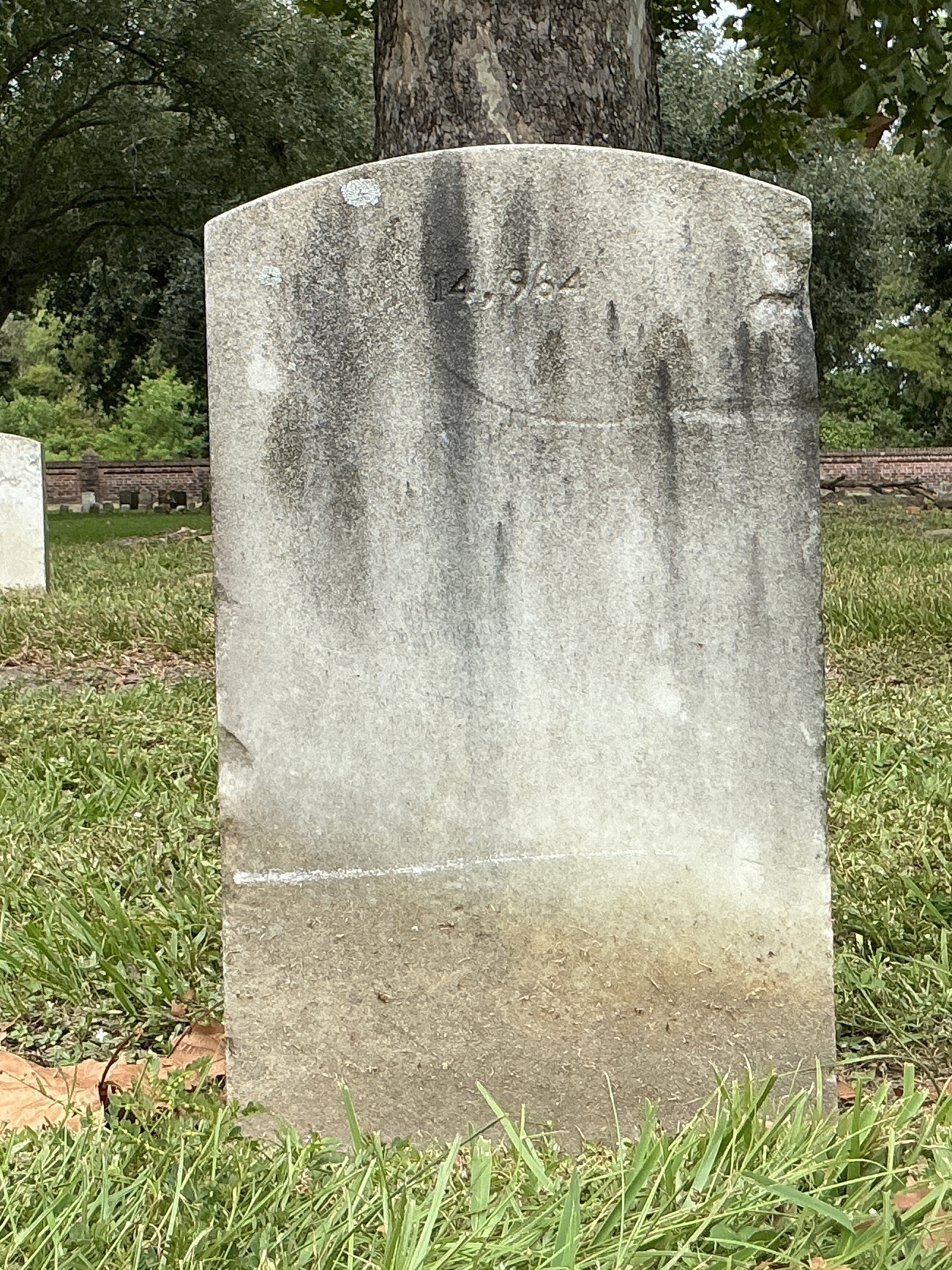 Back of upright marble headstone with flat face.