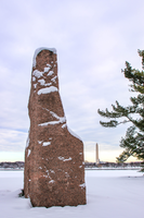 Granite monolith on a plaza after a snowfall with Washington Monument in the distrance