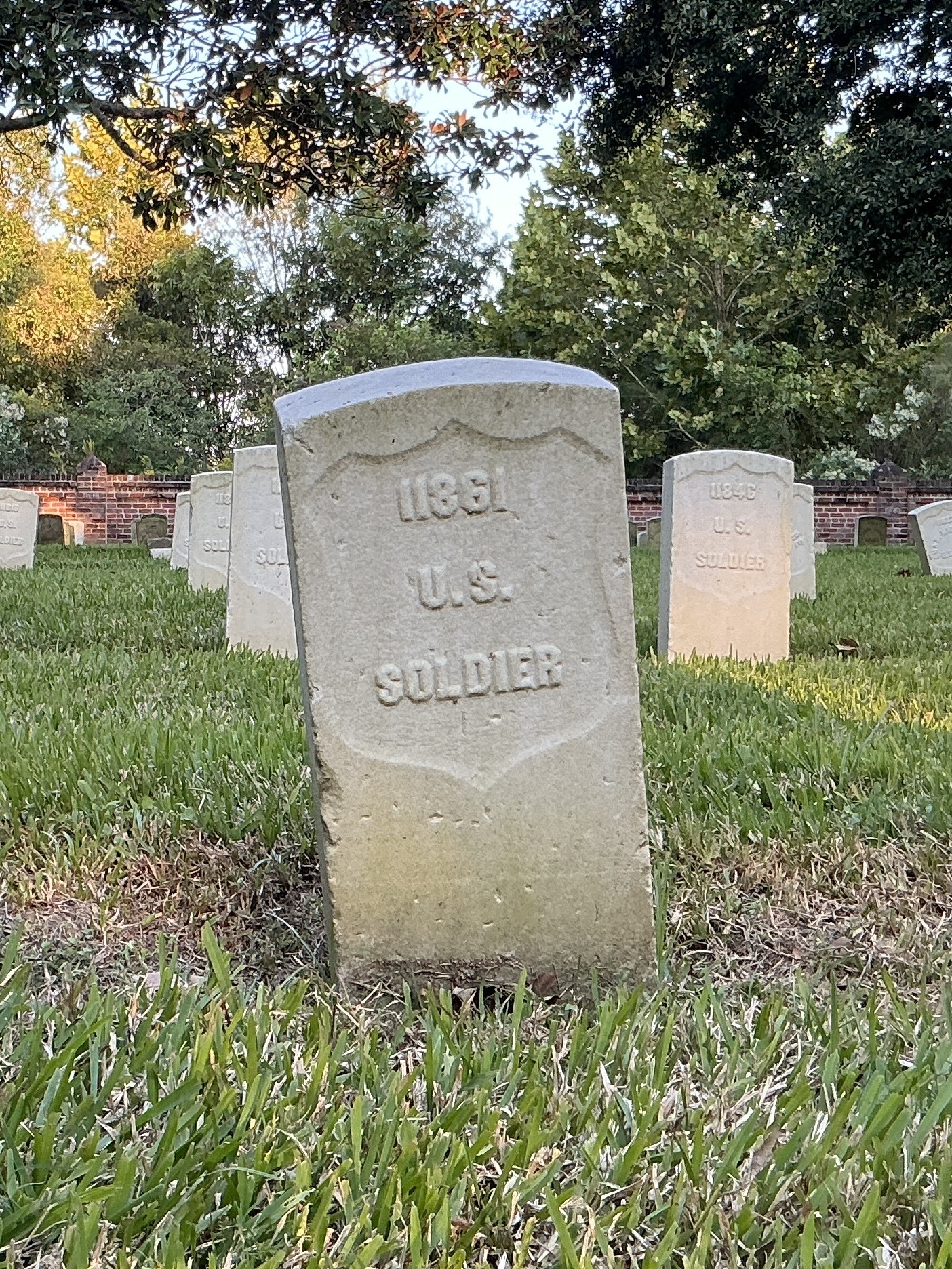 Front of historic upright marble headstone with recessed shield face.