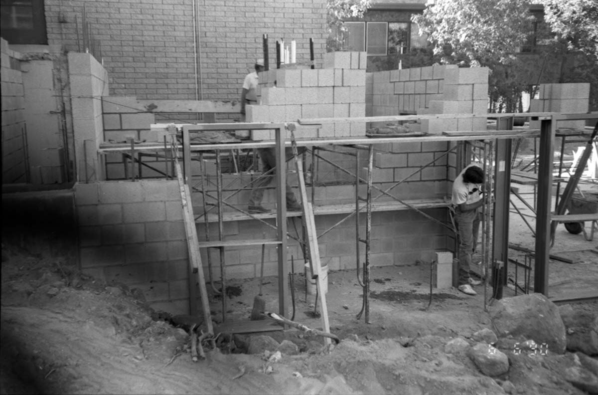 Man worker laying bricks during the construction of headquarters addition.