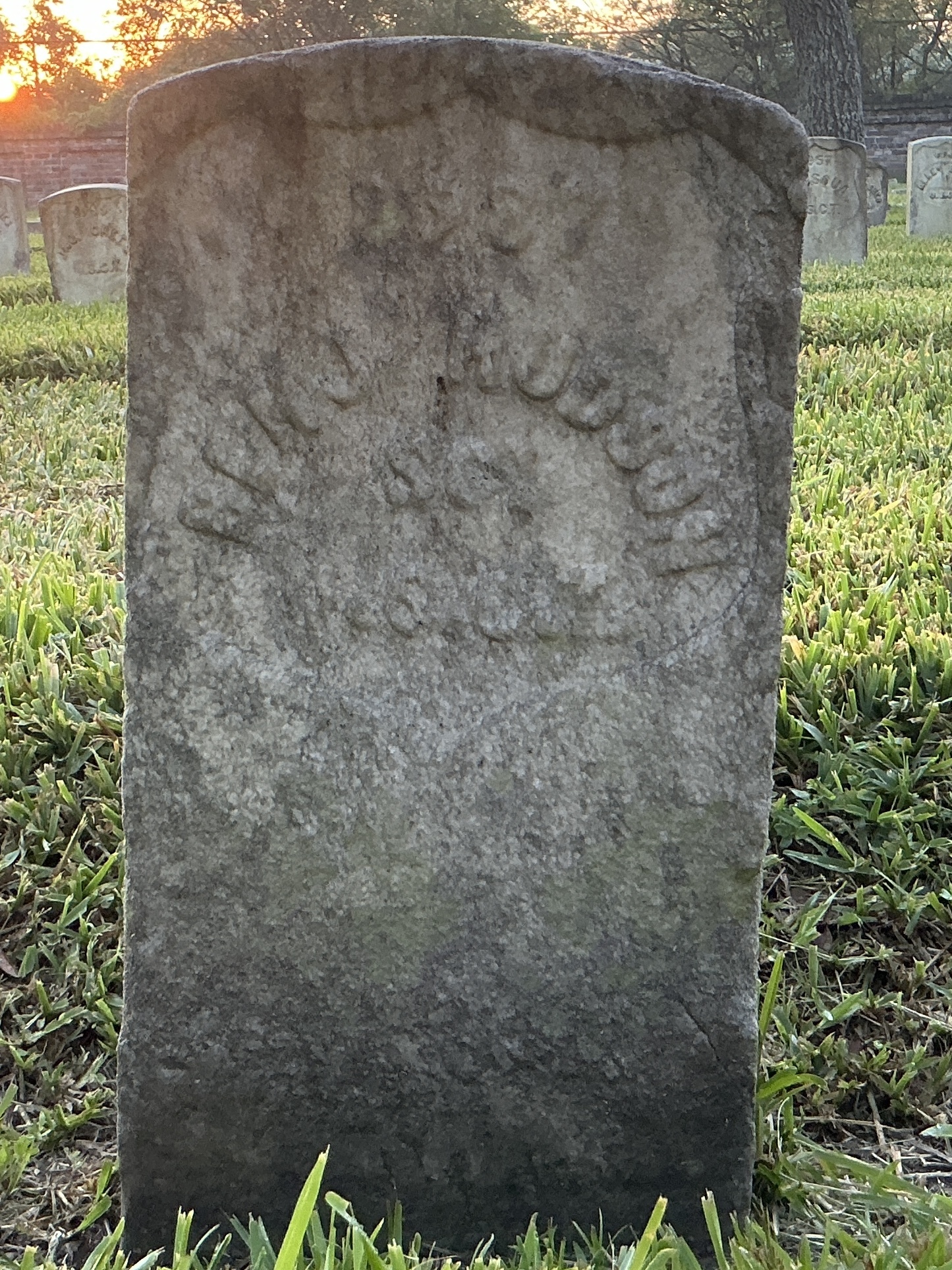 Front of historic upright marble headstone with recessed shield face.