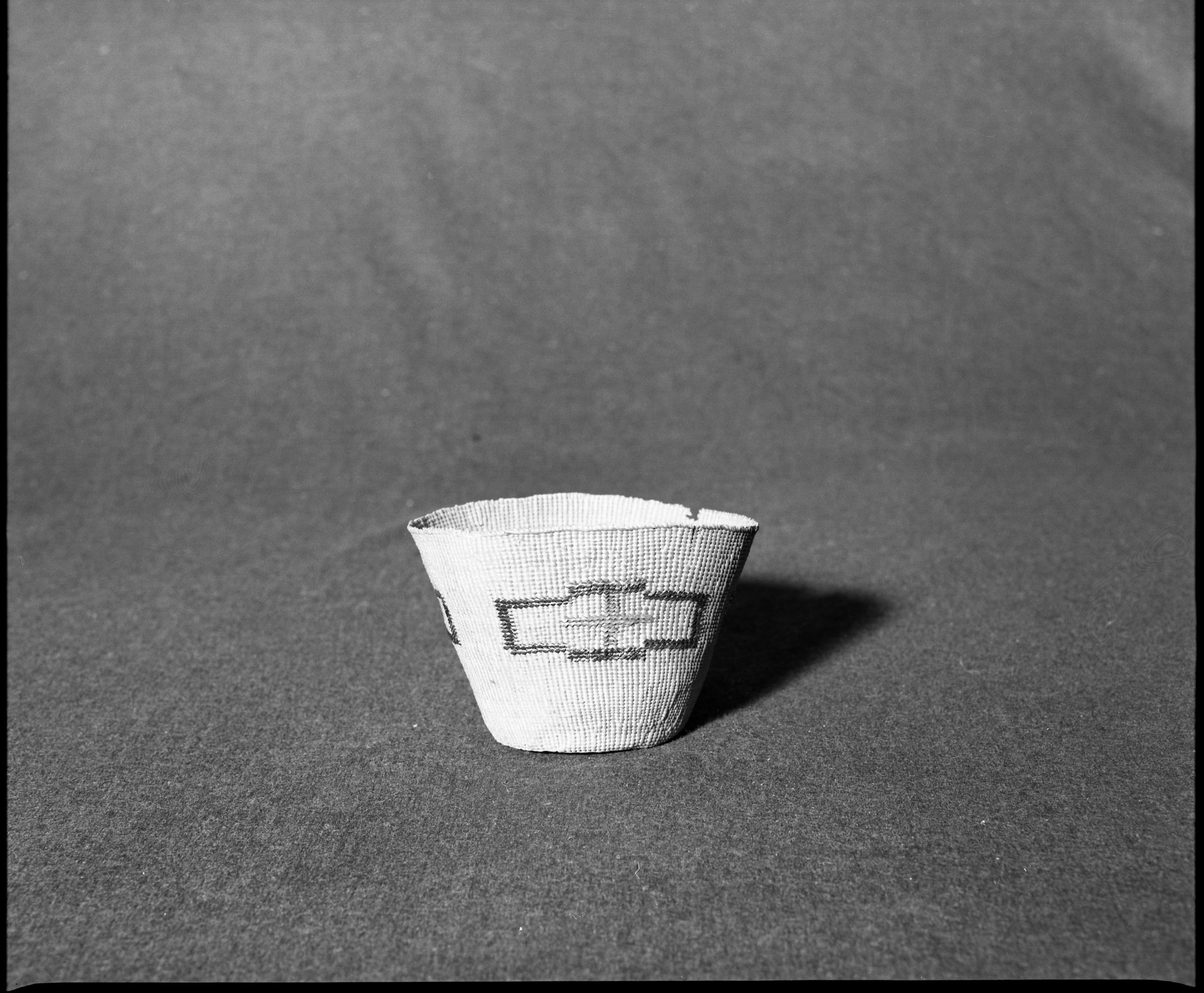 Marie Rozier Collection, Catalog No. 82. Object: Tlingit basket. Dimensions: 4 1/2 x 3". Materials: Red cedar, maidenhair fern stem. Technology: Down to right slant of turns. Collection History: From Carrie Johnson. Photographed by Michael Dixon, December 1982. Catalogued by Craig Bates and Barbara Beroza. Yosemite Collections, National Park Service.