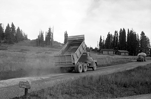 Dump truck and tanker truck constructing gravel spur road to Cedar Breaks Lodge. Trucks owned by contractor W.W. Clyde.
