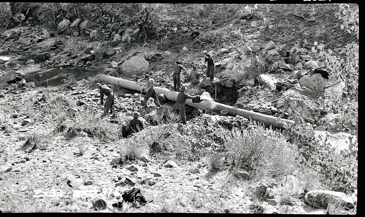 Pine Creek irrigation system with workers laying pipe.