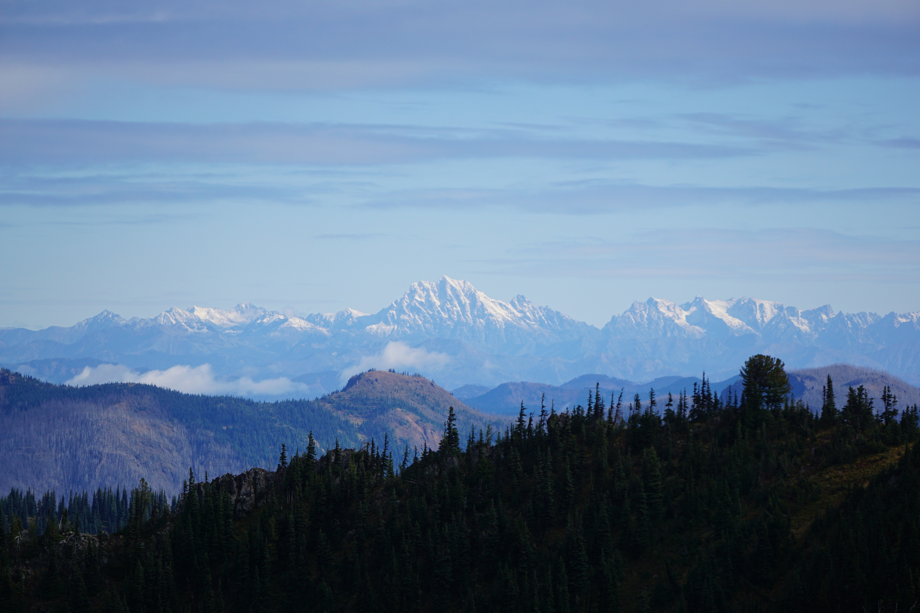 A distant snowy jagged mountain range with a prominent central peak. 