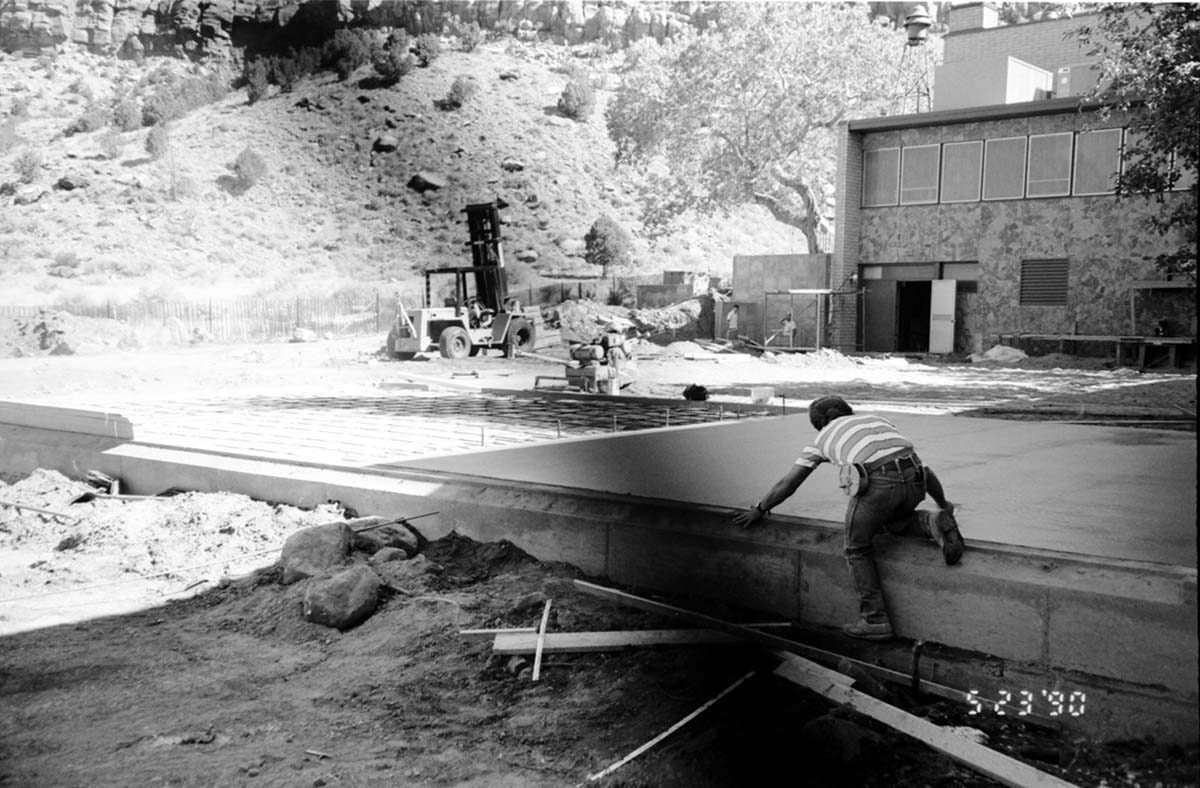 Men leveling concrete during the construction of headquarters addition.