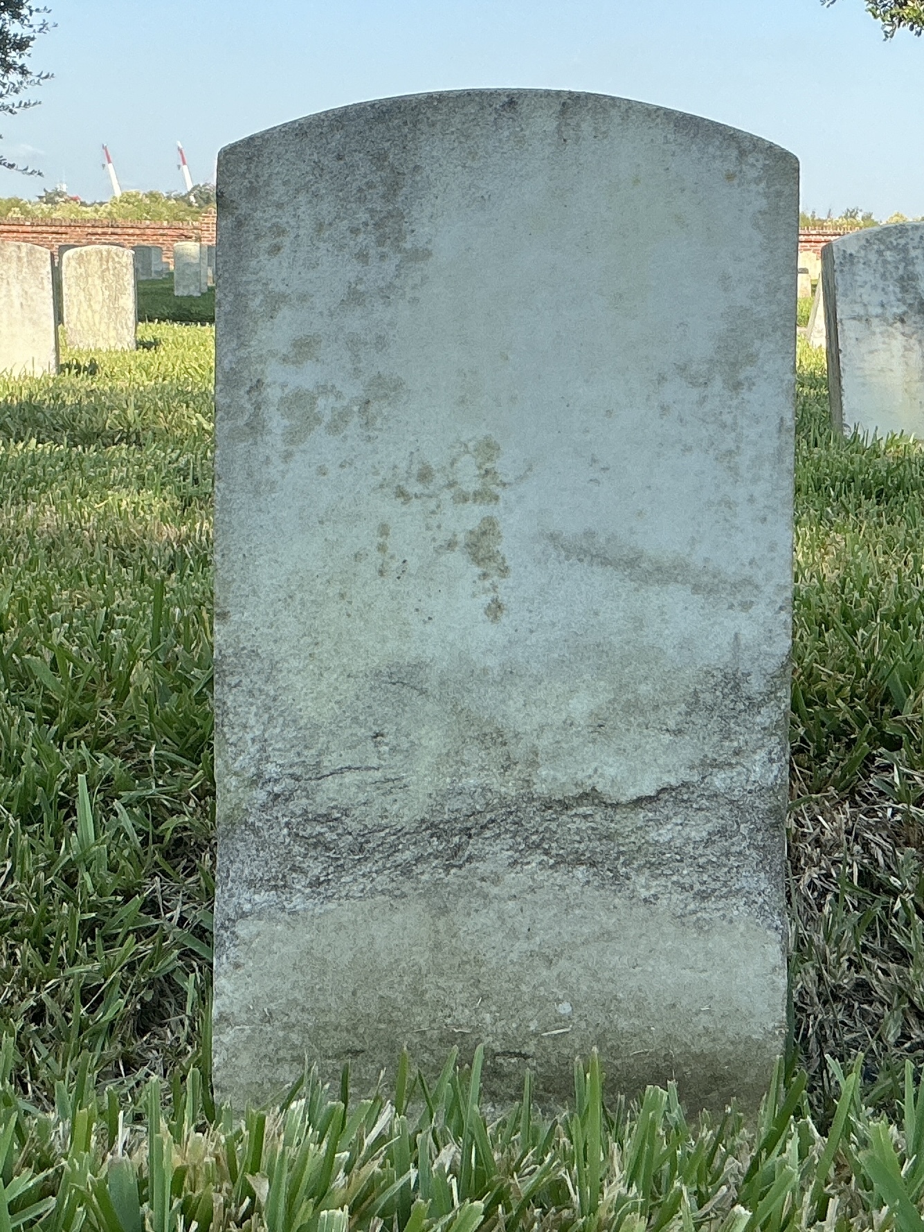Back of historic upright marble headstone with recessed shield face.