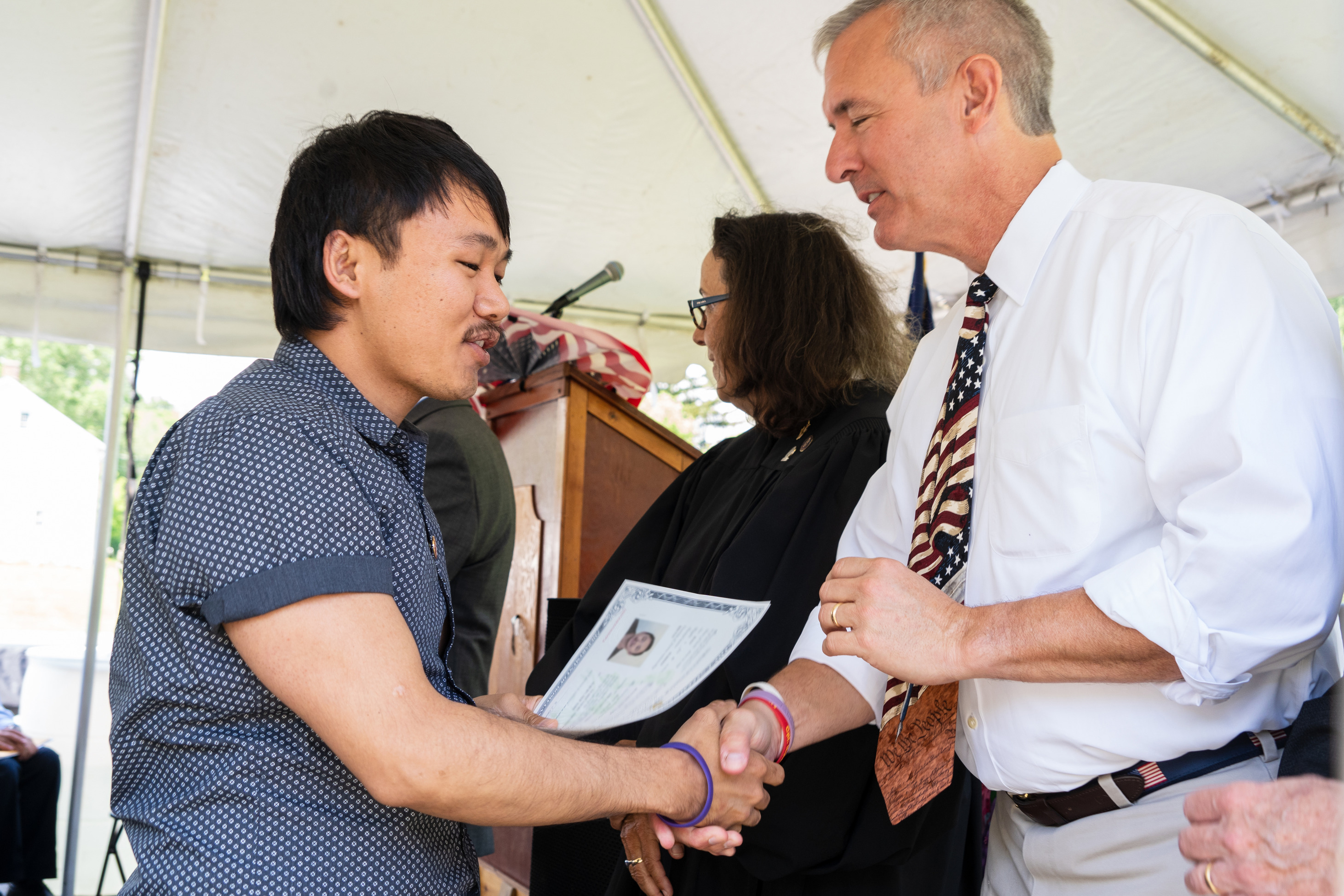 A man receives a certificate and a hand shake.