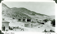 This is an historic black and white photograph from the Scotty's Castle Historic Photograph Collection, Death Valley National Park of Scotty's Castle Hacienda at end of construction. Retaining Wall before cactus garden. Road leading to Stables. June 25, 1929. Photographed by Mat Roy Thompson.