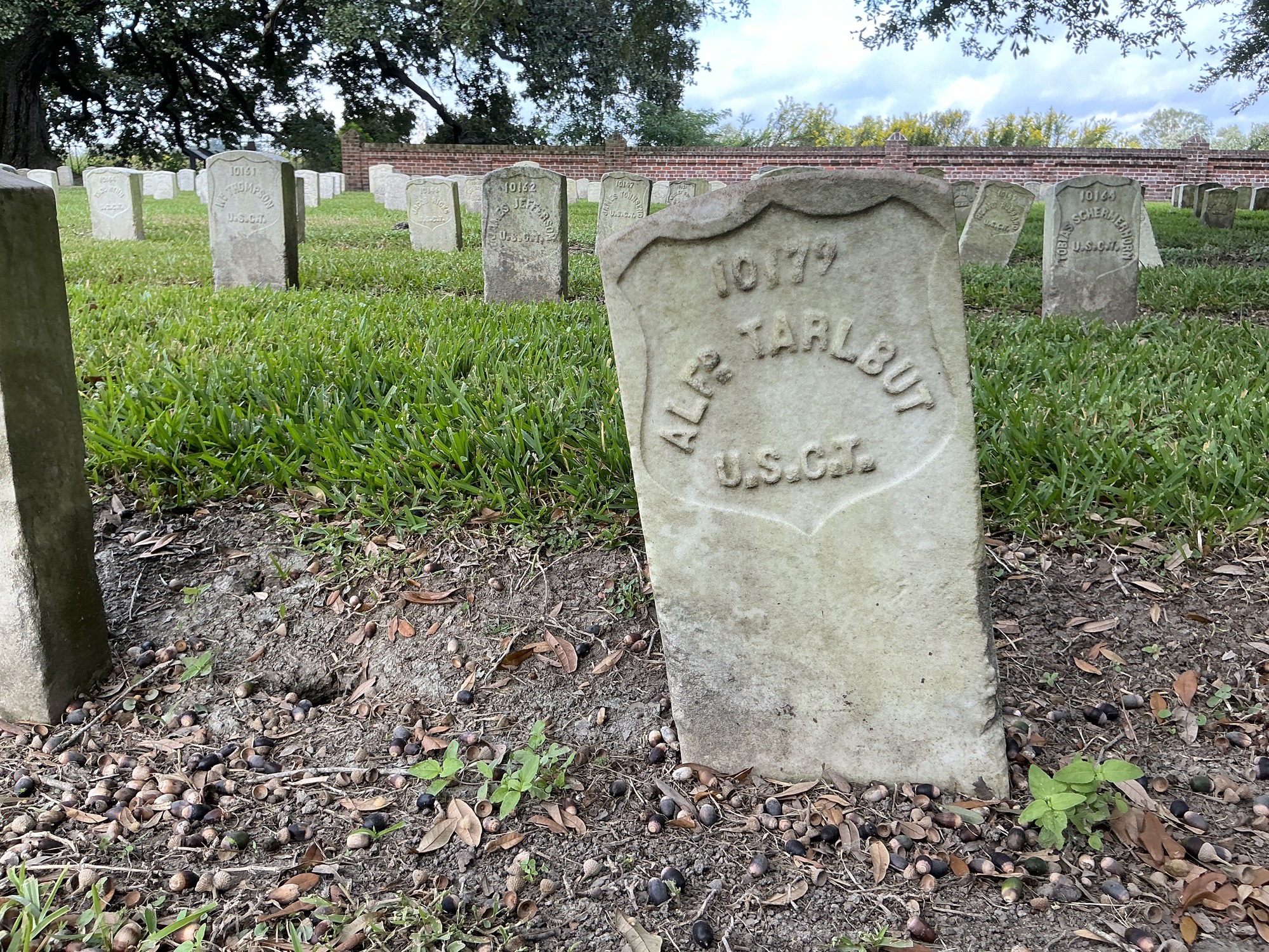 Front of historic upright marble headstone with recessed shield face.