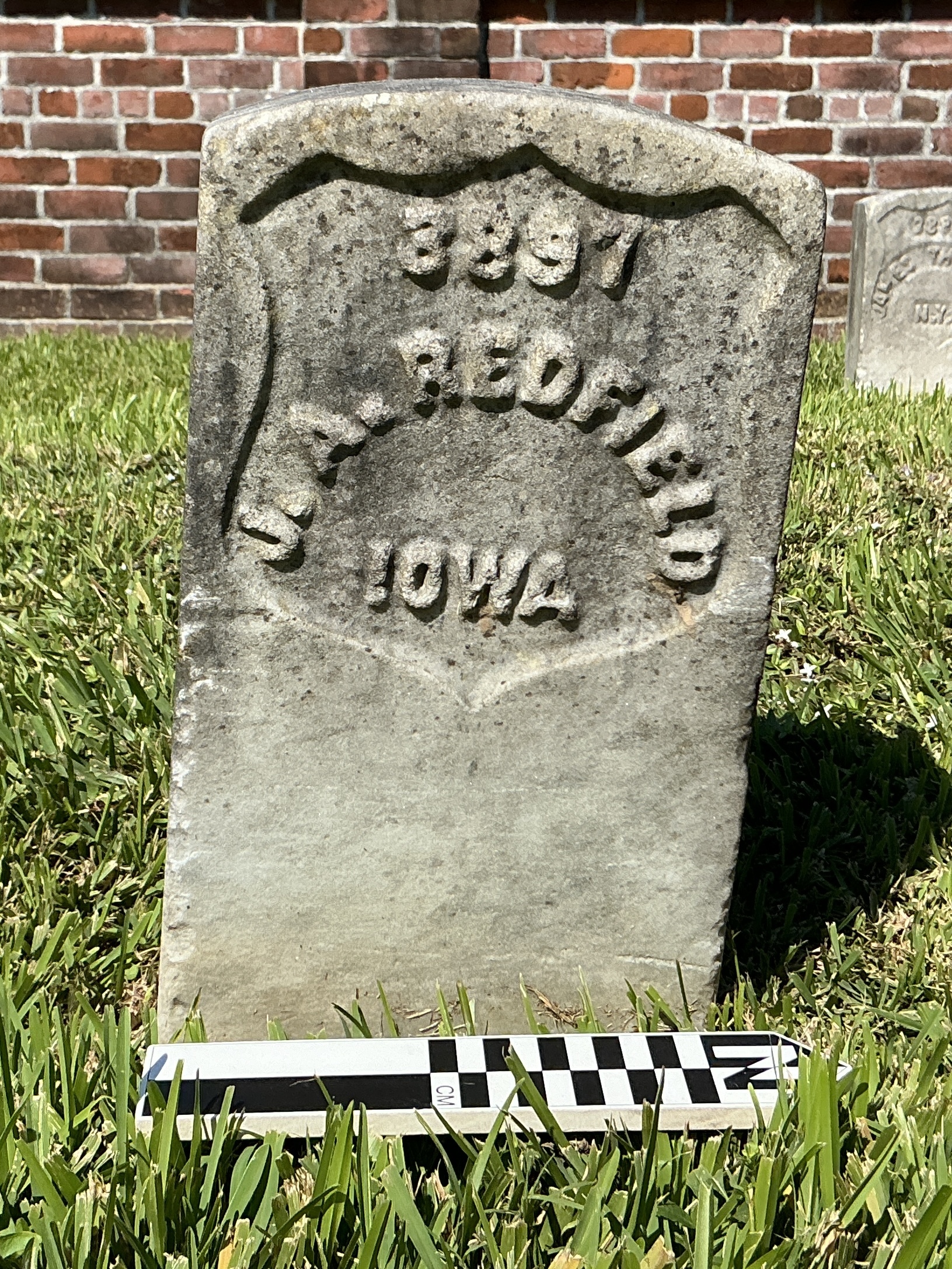 Extra image of historic upright marble headstone with recessed shield face.
