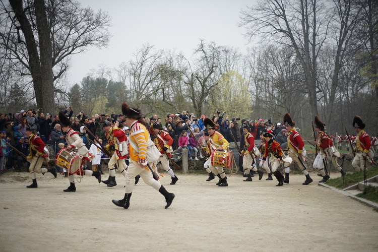 British troops running away from the North Bridge, past large group of spectators. 