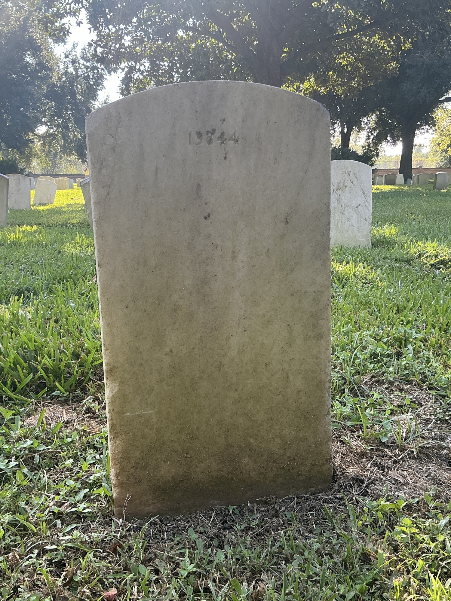 Back of upright marble headstone with flat face.