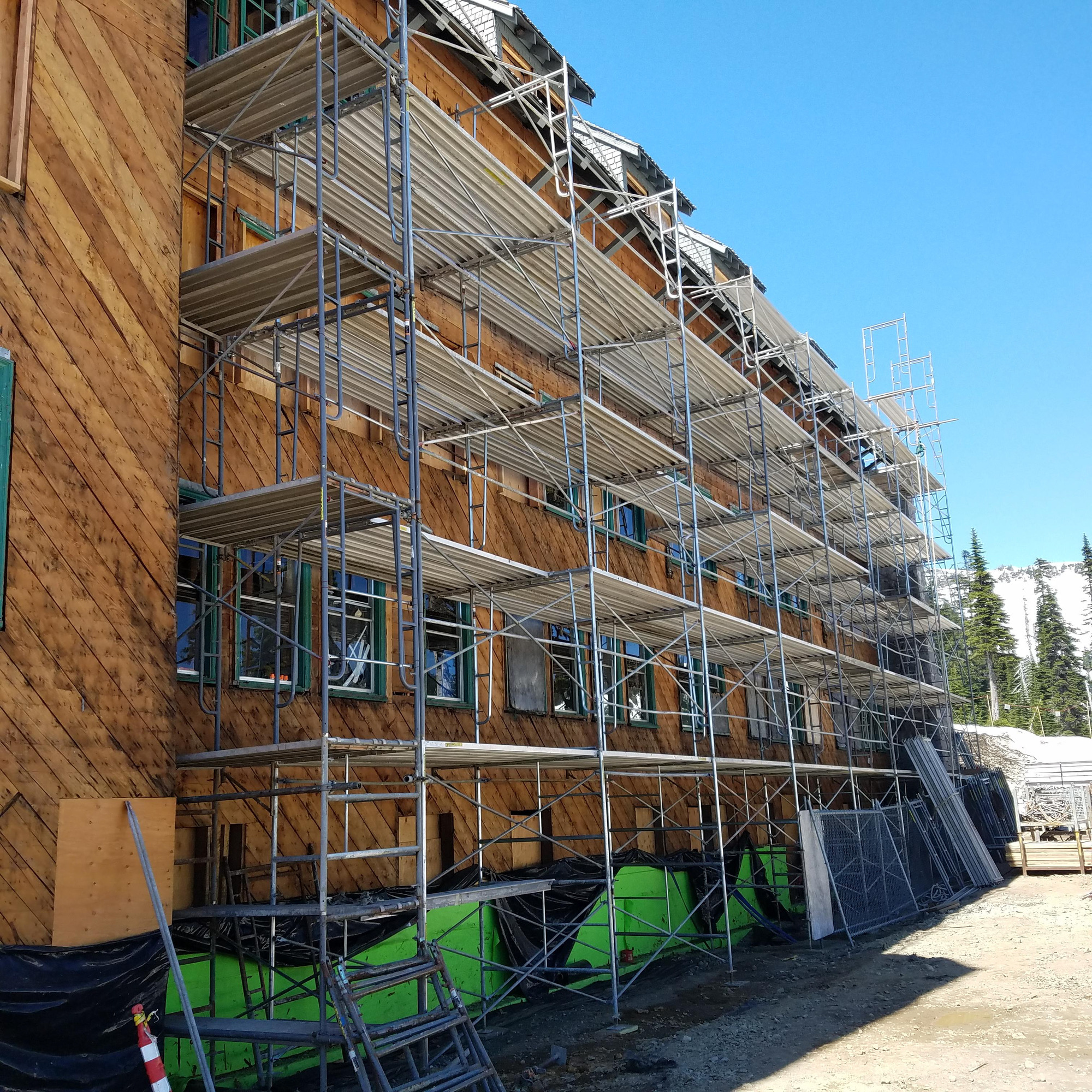 Scaffolding fills the side of a large, four-story building. 