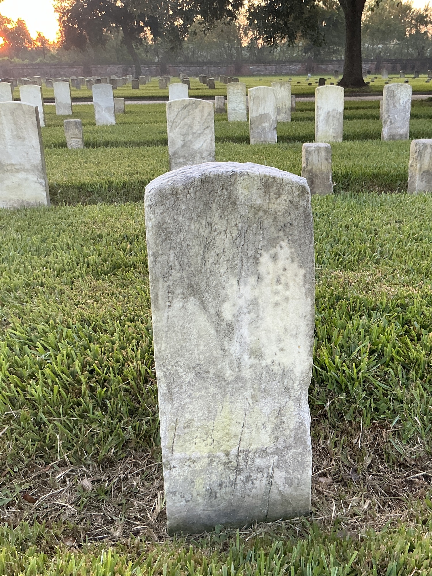 Back of historic upright marble headstone with recessed shield face.