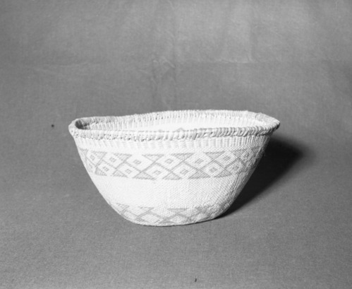 Mrs. Donald Segerstrom Collection. Object: Northern Paiute or Washoe basket. Dimensions: 15 x 7 1/2". Materials: entirely willow with design in sunburned willow patched up with dye. Technology: three strand twined start, body of basket in diagonal twining, four rows of palin twining over paired warps at selvedge. Photographed by Michael Dixon, January 1983. Catalogued by Craig Bates and Barbara Beroza. Yosemite Collections, National Park Service.
