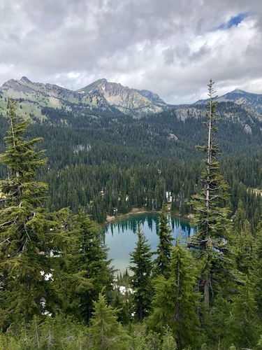 Forests surround anneal lake with mountains in the background.