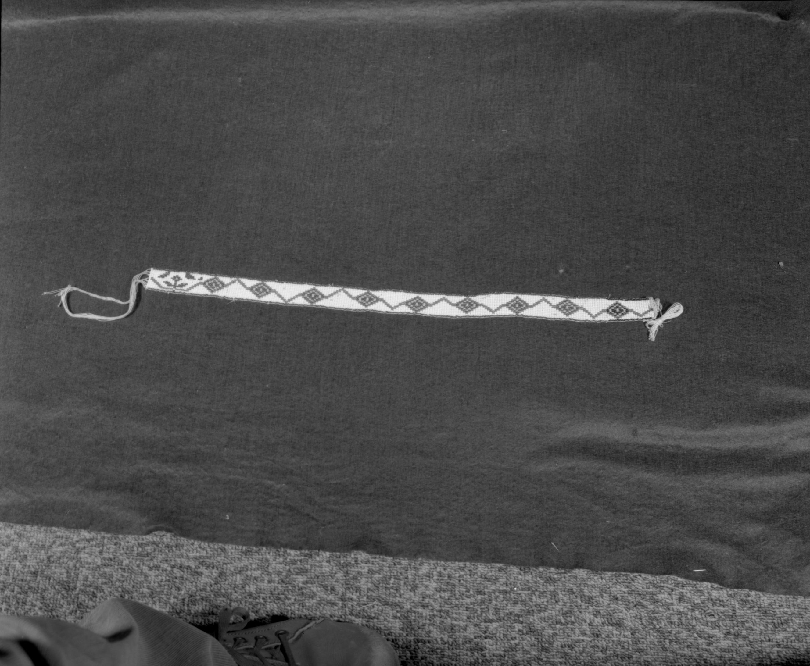 Marie Rozier Collection, Catalog No. 137. Object: Miwok beaded hatband. Dimensions: 21 x 1". Materials: Cotton thread; white, green, red and yellow beads. Technology: Made by Mrs. Louise Fuentes in 1950s. Collection History: Purchased from Mrs. Fuentes. Photographed by Michael Dixon in December 1982. Catalogued by Craig Bates and Barbara Beroza. Yosemite Collections, National Park Service.