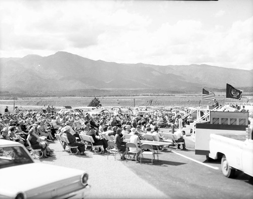 Man addressing visitors from podium at the dedication of Taylor Creek road (Kolob Canyons).