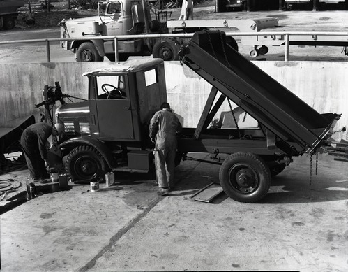 Painting FWD snow plow in maintenance area.
