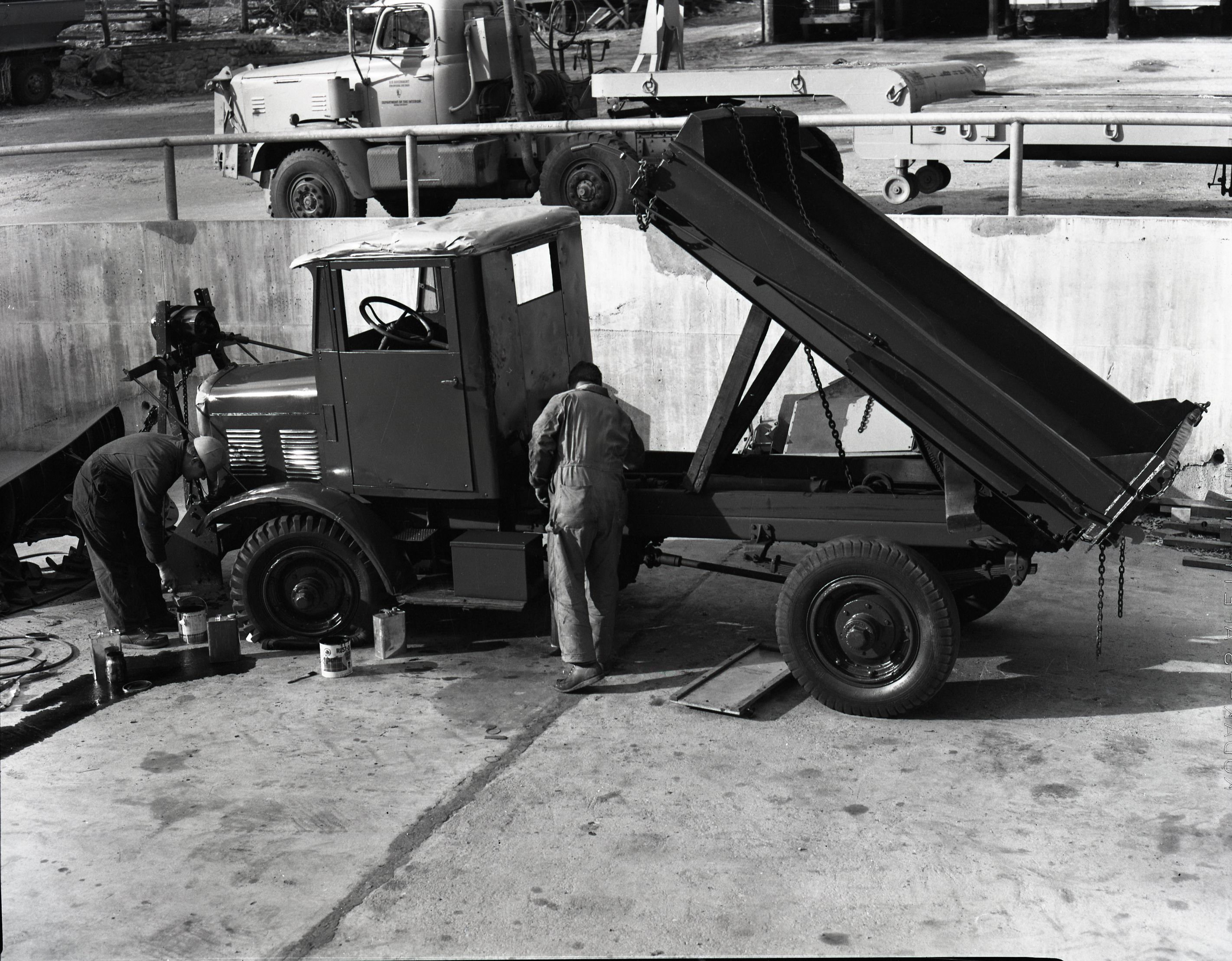 Painting FWD snow plow in maintenance area.