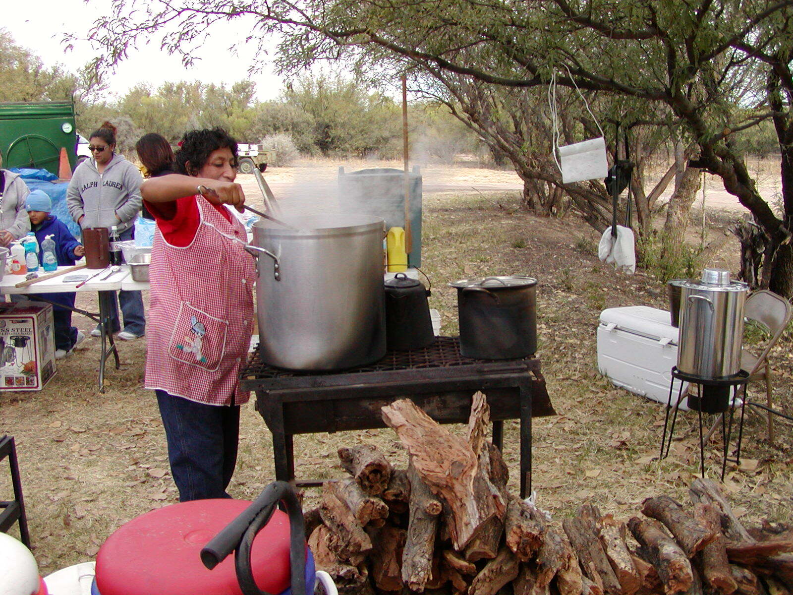 Woman cooking over a very large pot