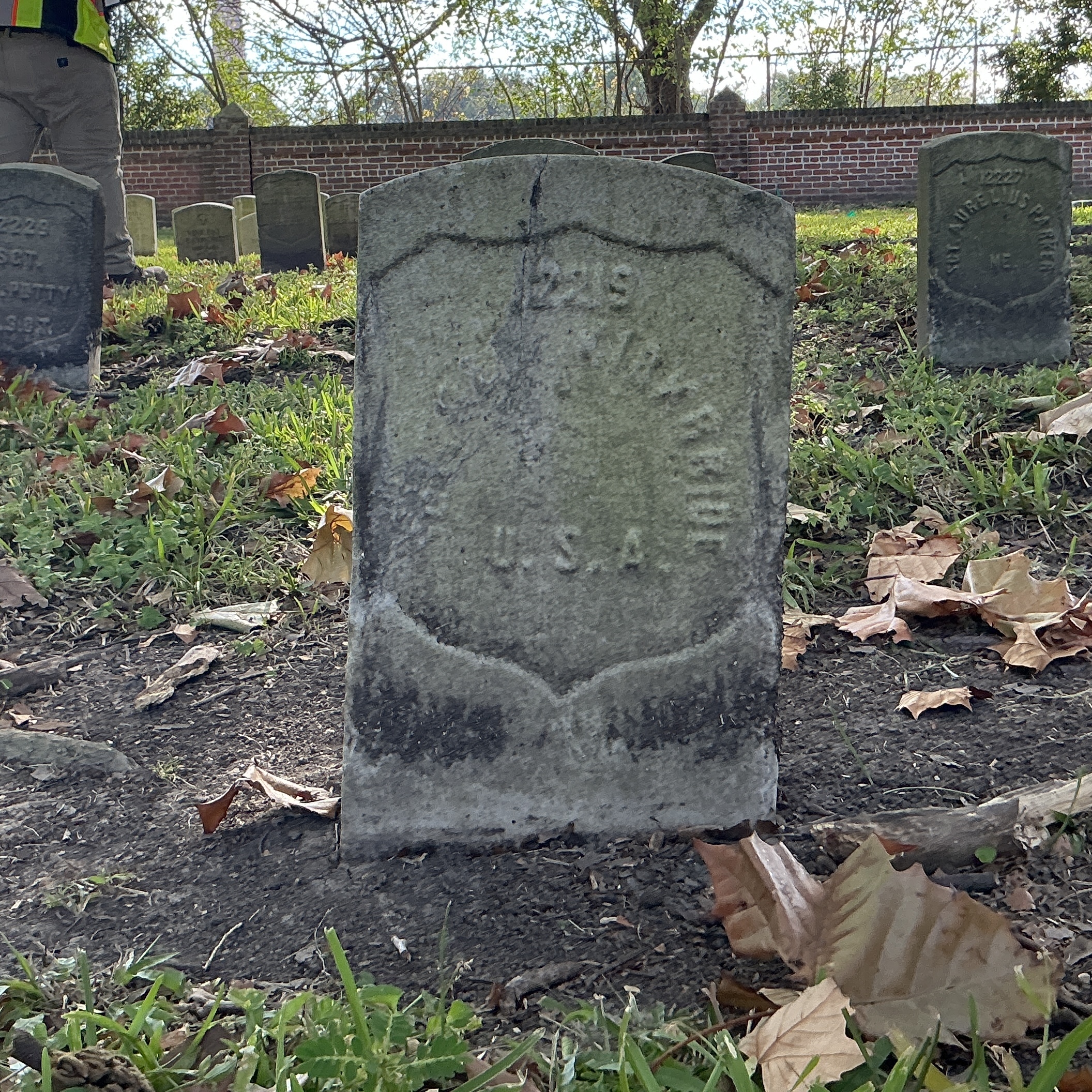 Front of historic upright marble headstone with recessed shield face.