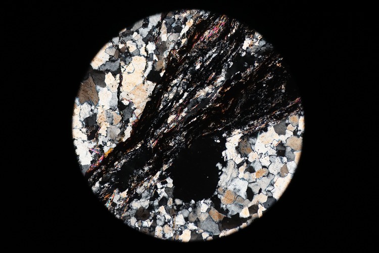 Circular microscopic image of rock structure.