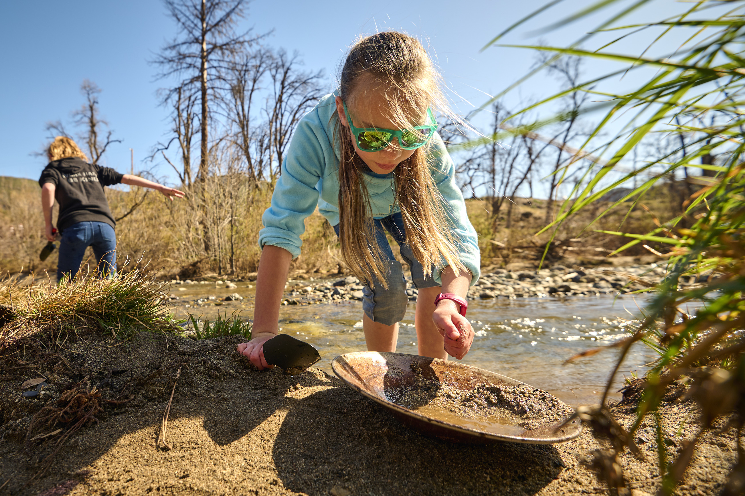 A student gold panning in a creek.
