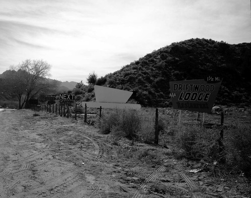 Roadside signs in Springdale. Several signs on turn of road - Driftwood Lodge and others.