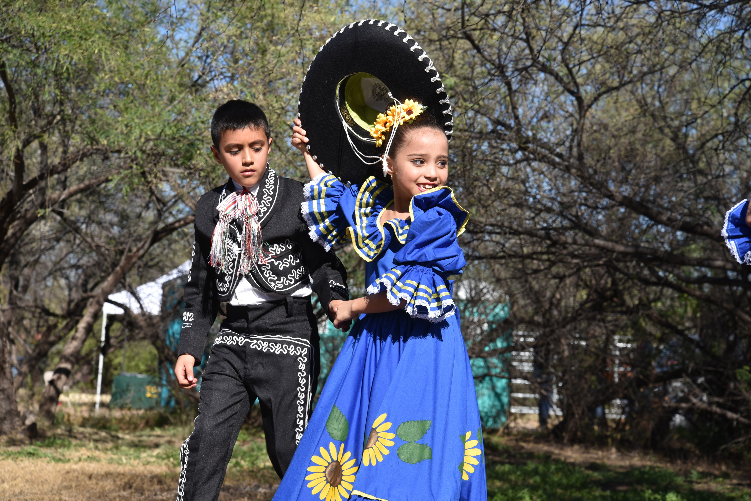 young children in traditional Mexican folklórico costumes, dancing