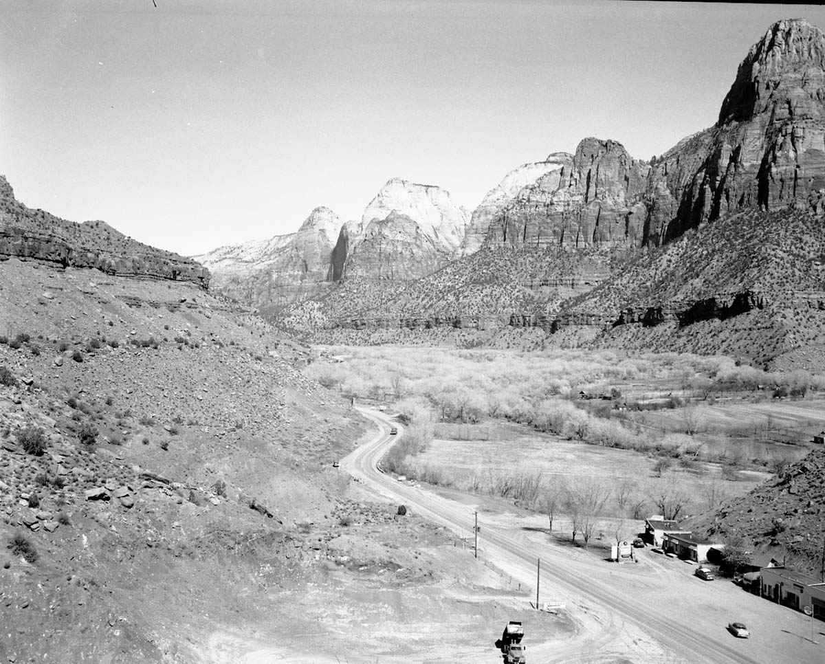 The mouth of Zion Canyon with 'Zionville Market and Motel' in Springdale, Utah (in the foreground), 0.5 mile south Zion National Park South Entrance. Bridge Mountain at far right.