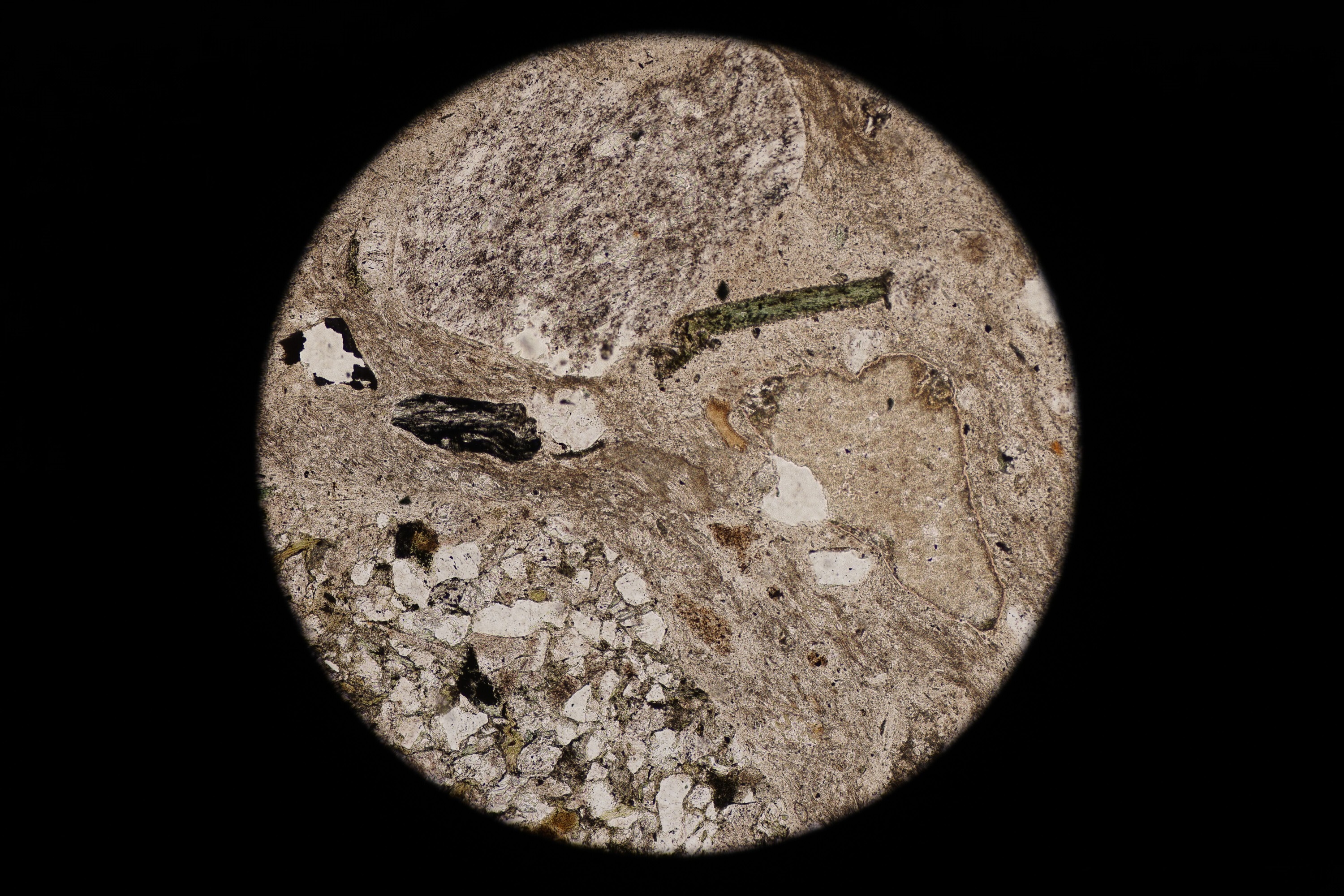 Circular microscopic image of rock structure.