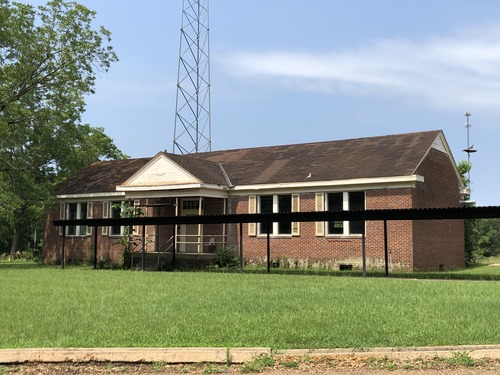 Exterior north facade of the Marion Rosenwald School with brick veneer, covered front porch, windows, and covered walkway.