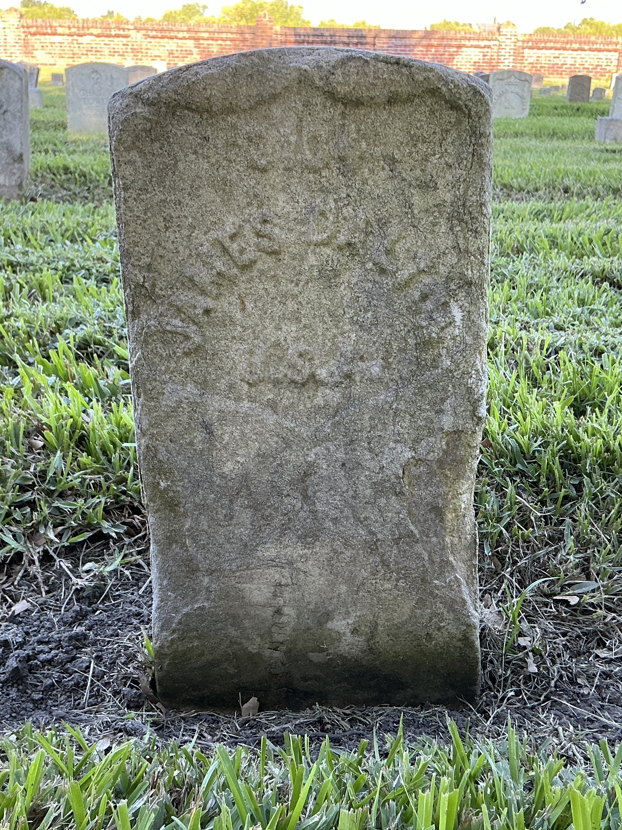 Front of historic upright marble headstone with recessed shield face.