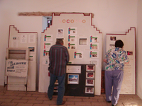 A man and a woman looking at a display of pictures.