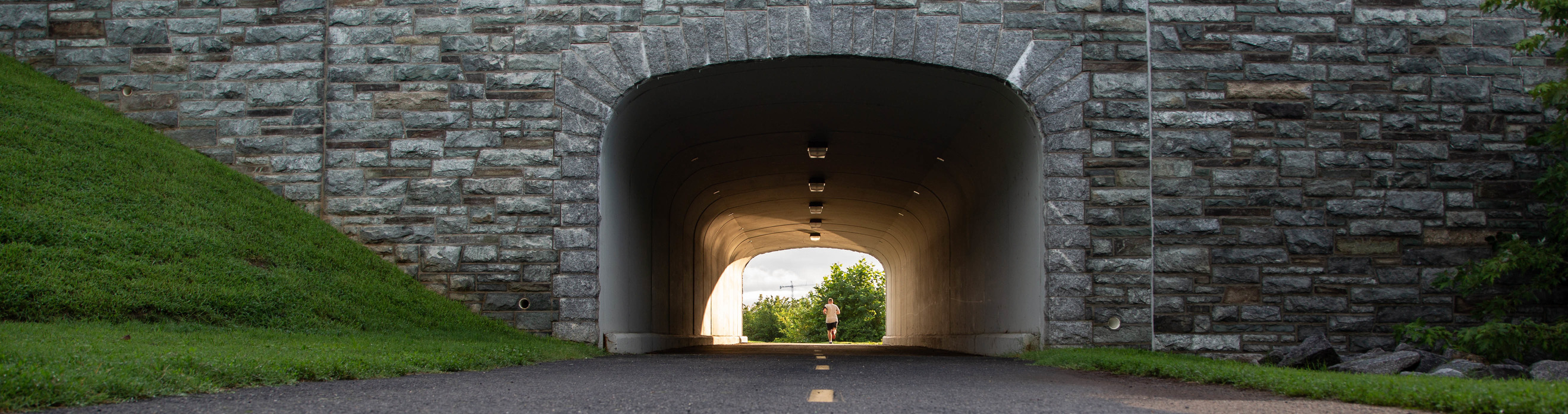 Jogger under a stone bridge