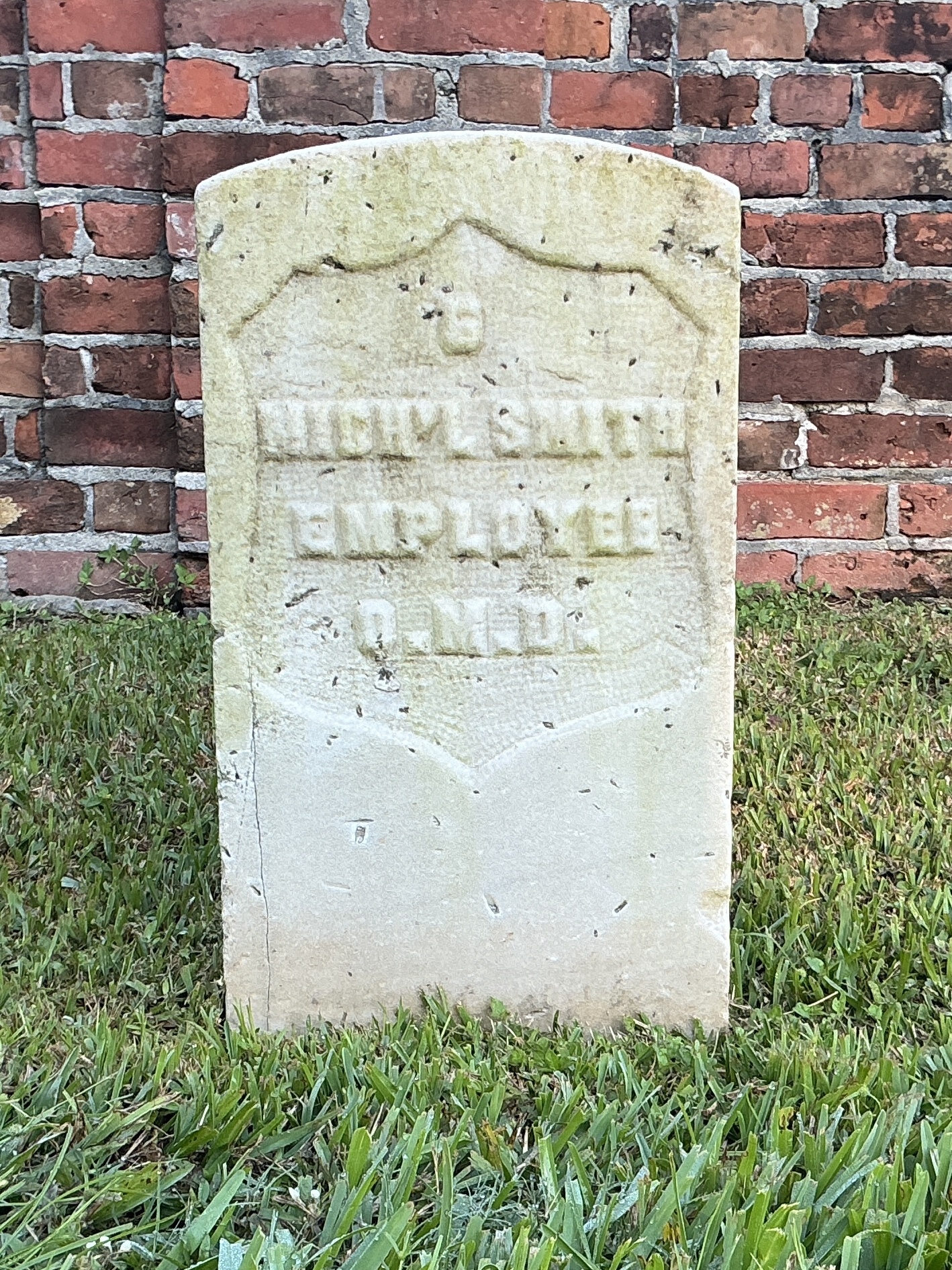 Front of historic upright marble headstone with recessed shield face.