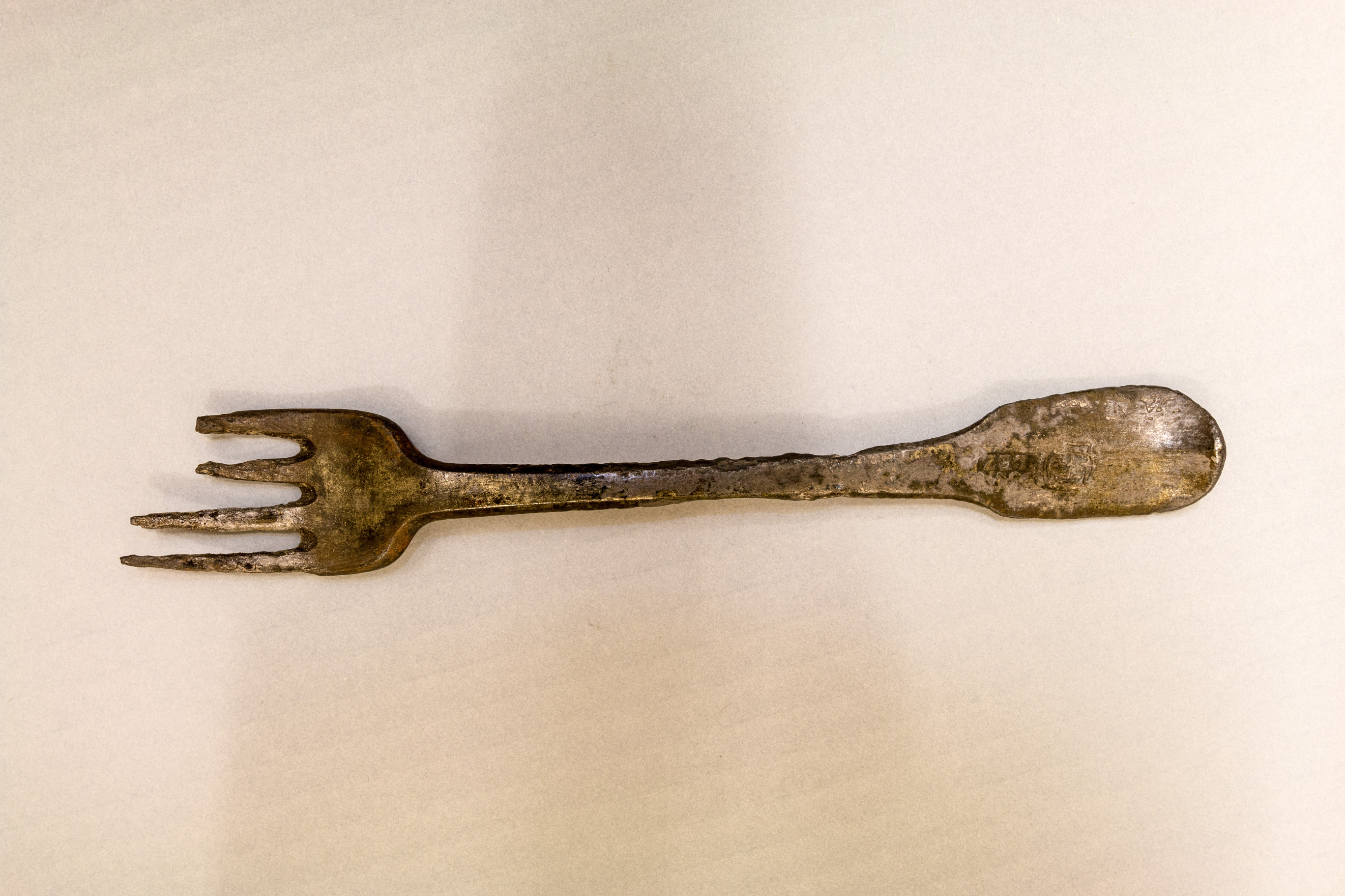 A tarnished silver fork with two broken tines
