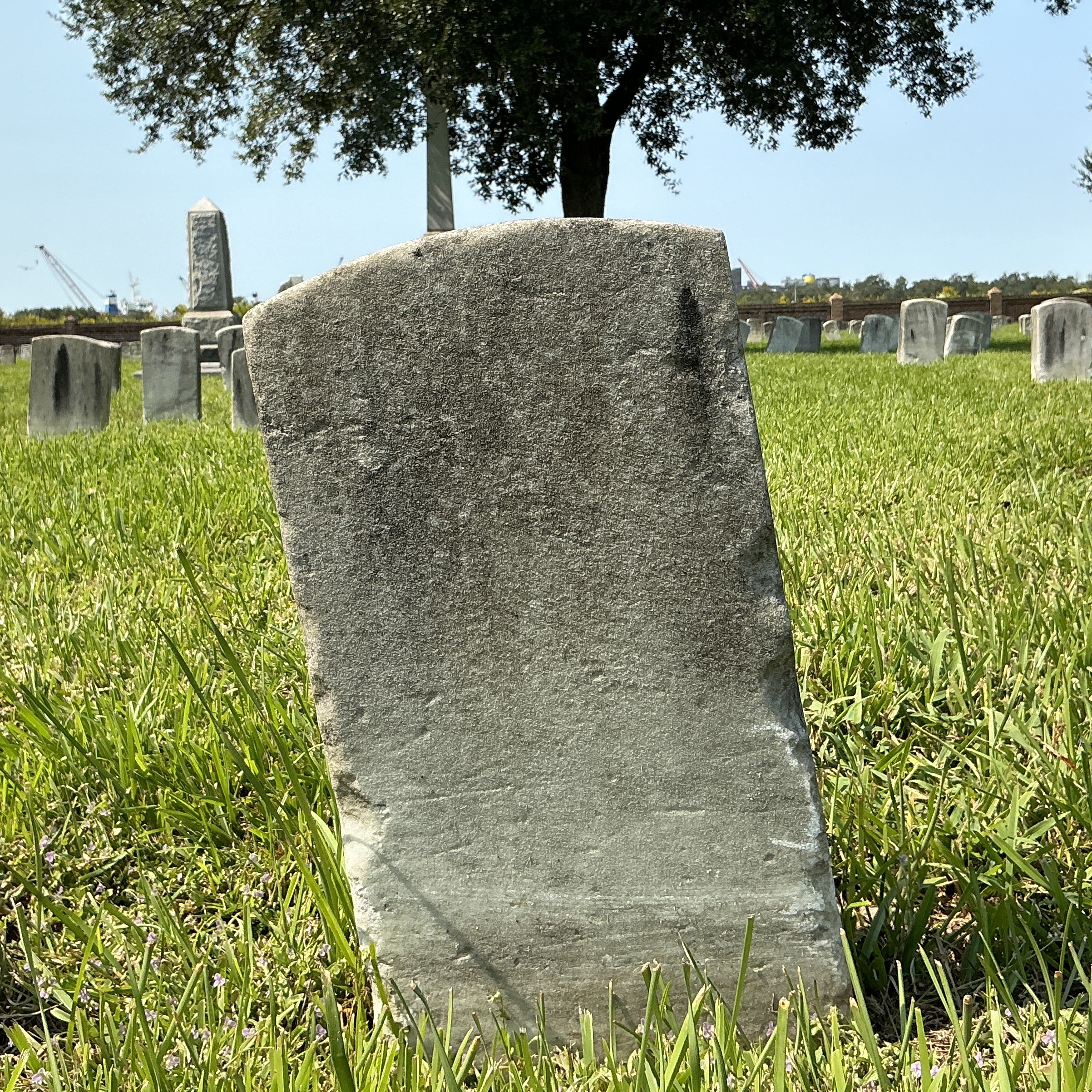 Back of historic upright marble headstone with recessed shield face.