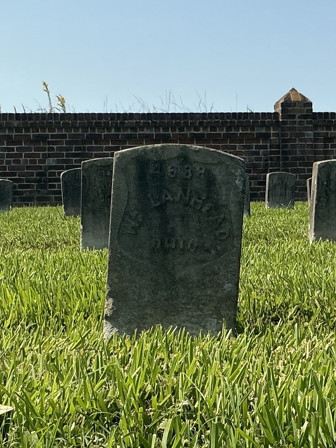 Front of historic upright marble headstone with recessed shield face.